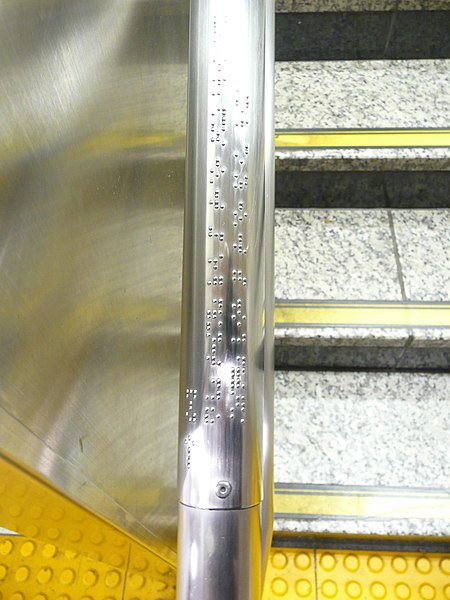 A handrail with braille messages on it.